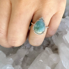 14k rose gold and diamond ring with a paraiba tourmaline center stone. 